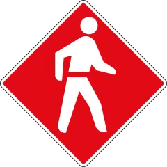 red pedestrian priority sign with walking figure symbol in urban area.